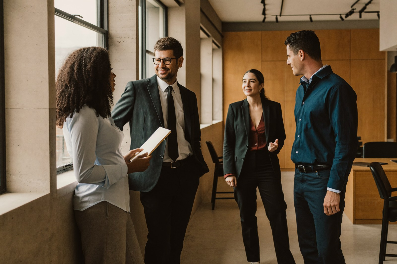 Four professionals talking together in an office